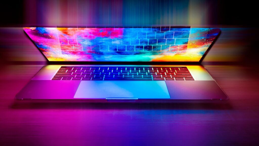 A half-closed laptop with a brightly coloured image of space on the screen