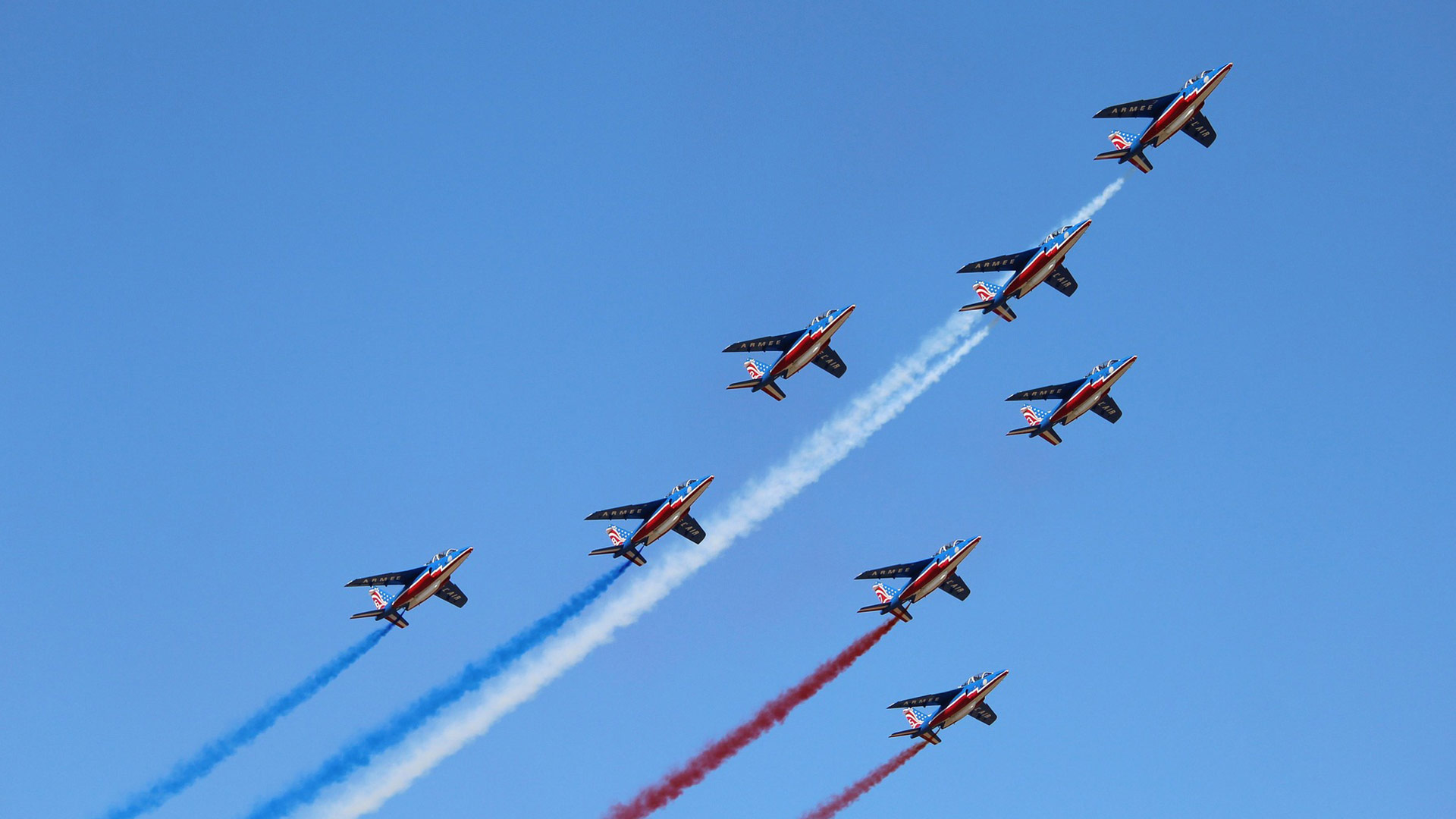 Planes in formation against a blue sky