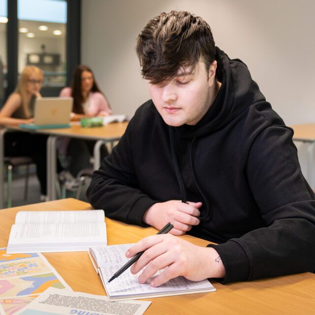 Ryan Smith sat at a table with a pen and paper.