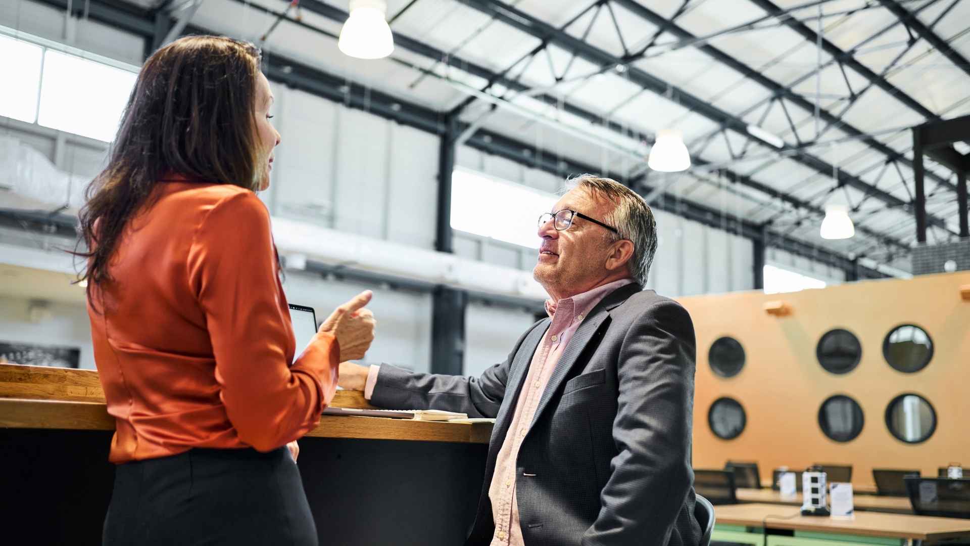 Two colleagues having a discussion in a industrial work environment.