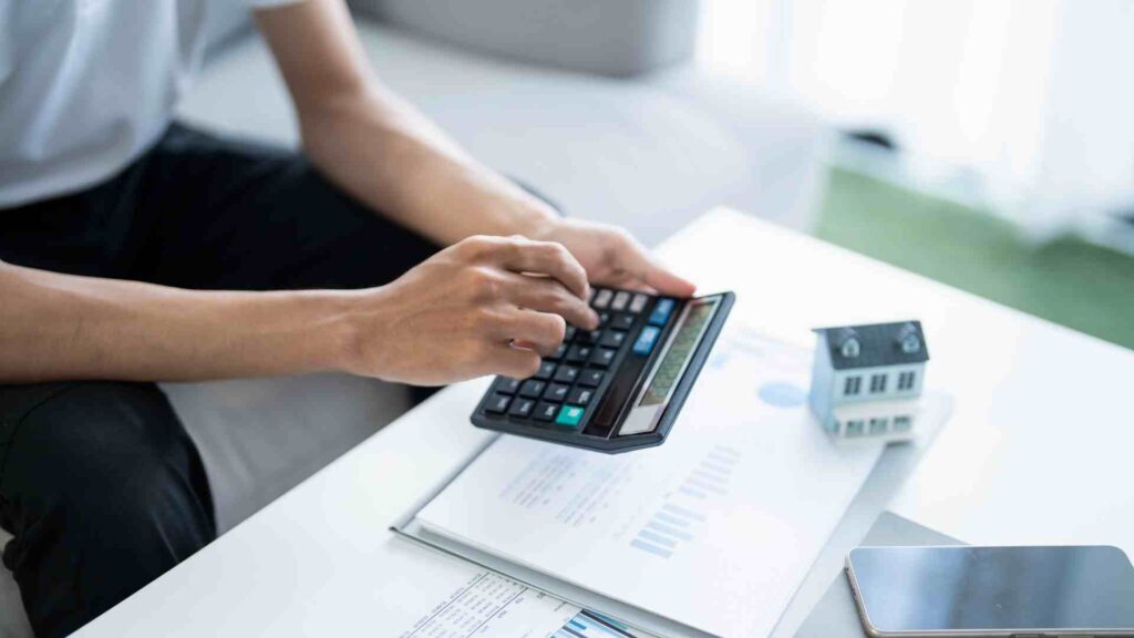 A hand of a business professional typing on a calculator.