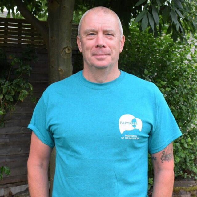 Headshot of Mike Palmer wearing cyan blue Papyrus t shirt