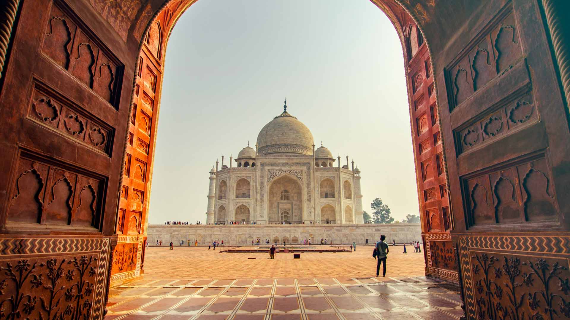 Picture of the Taj Mahal in India seen at a distance through a huge double doors exit