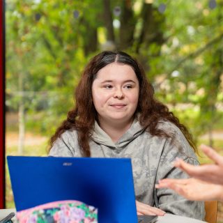 Kayla Doyle sat at a desk with a laptop