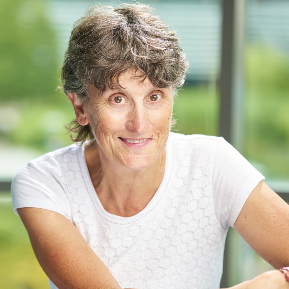 Portrait of Bernie Carter, looking straight at the camera and smiling, wearing a white short sleeve top. 