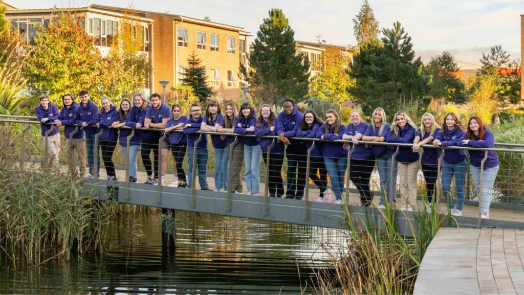 Group of campus connectors students stood on bridge posing for photo