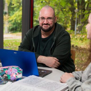 Daniel Murphy profile photo, sat at a desk with a laptop