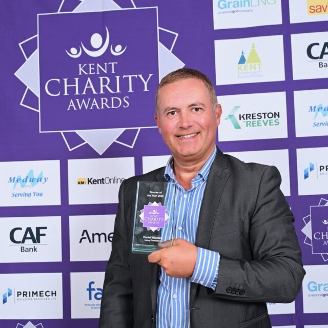 Daniel Valentine holding his Trustee of the Year award