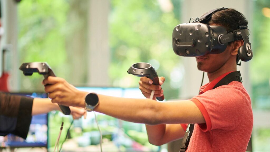 Student wearing a virtual reality headset and holding a controller out in front