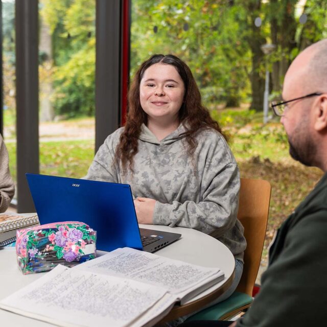 Kayla Doyle sat at a desk with a laptop