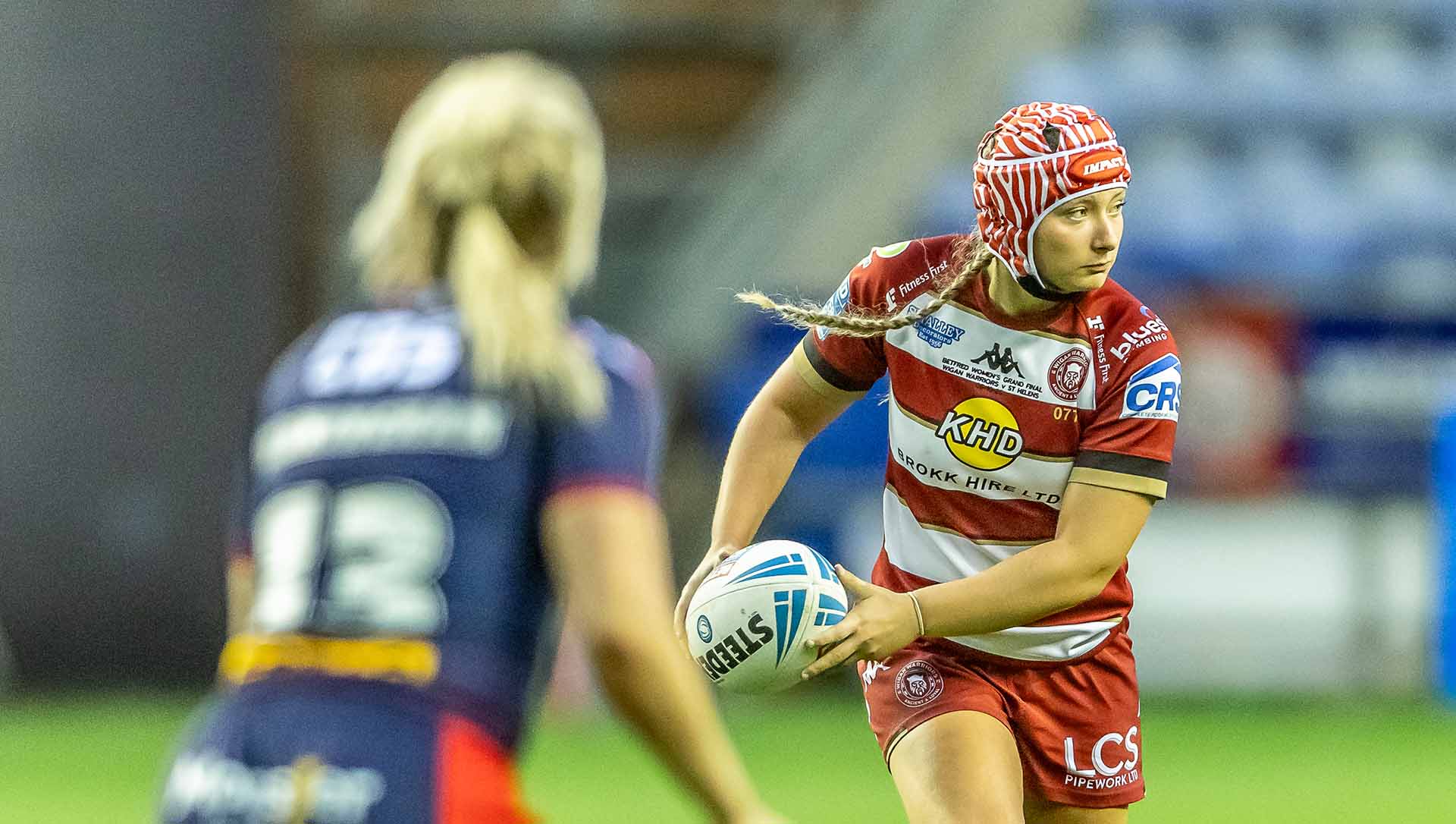 Izzy Rowe makes apass while competing for Wigan Warriors RLFC.