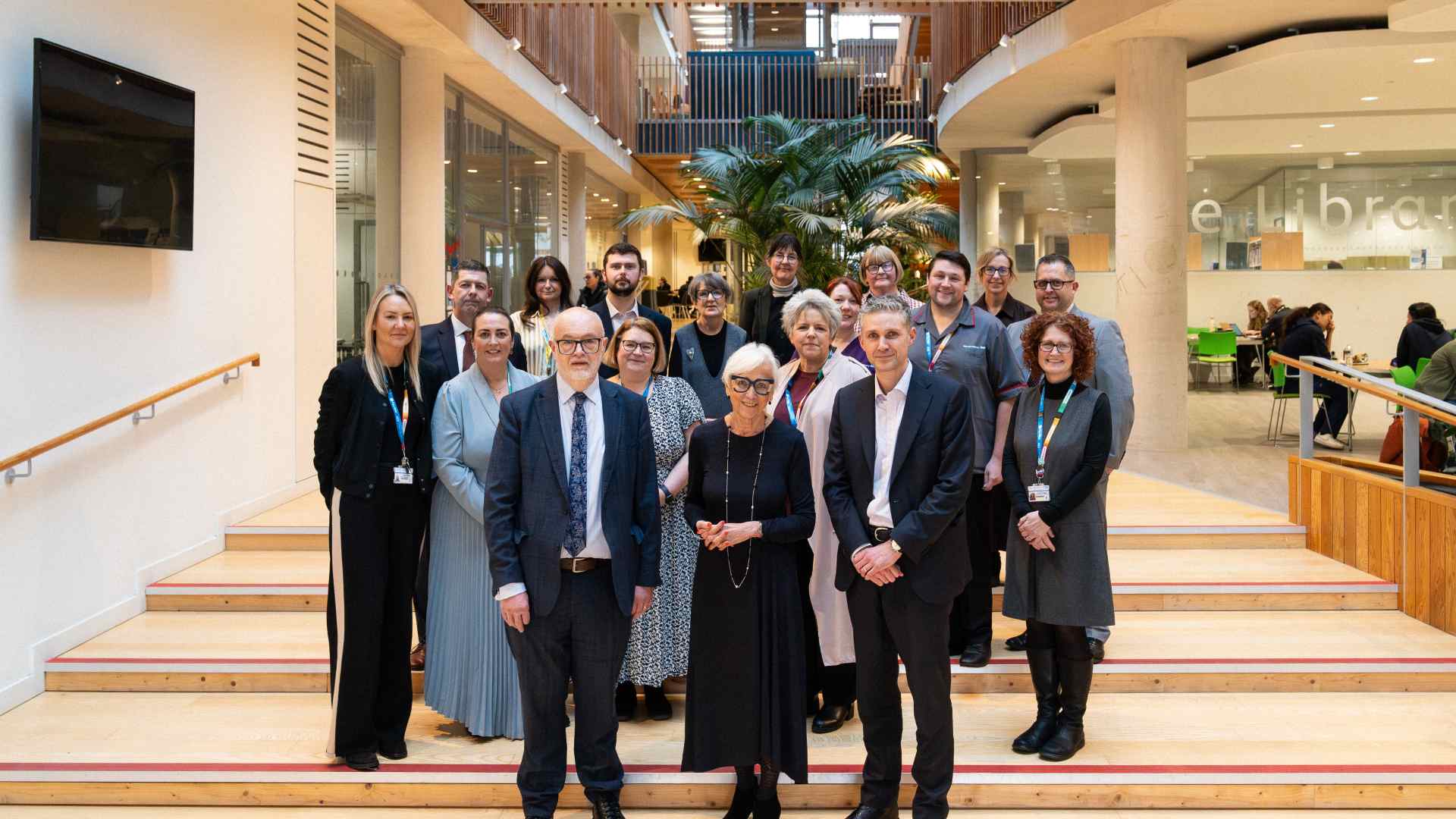 image of Alder hey and Edge Hill staff, standing on wooden steps looking at the camera.