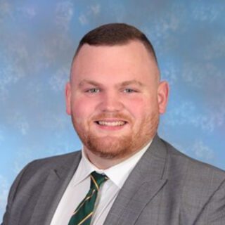 Callum O'Neill wearing a suit in a professional staff photo