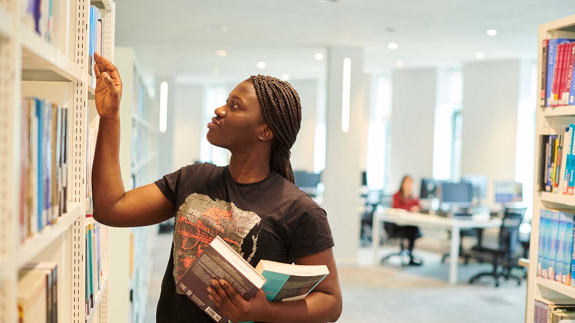 Postgraduate student browsing the shelves of our library