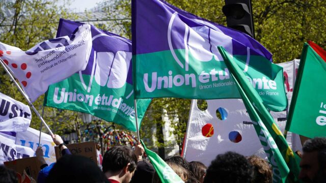 People outside waving purple and light blue union flags
