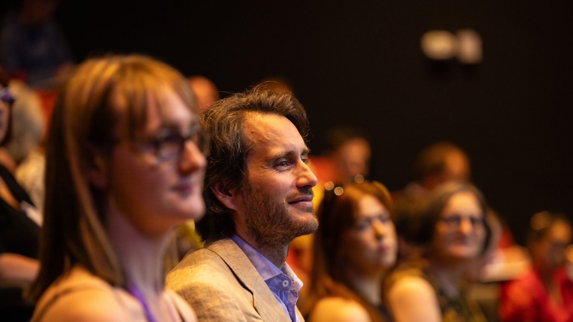 People sit in a lecture theatre taking part in a conference