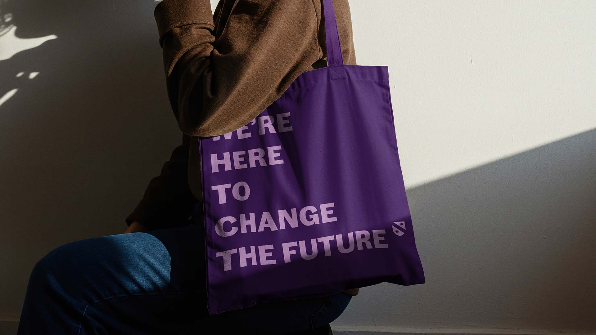 A mock up of a purple tote bag, with the words, 