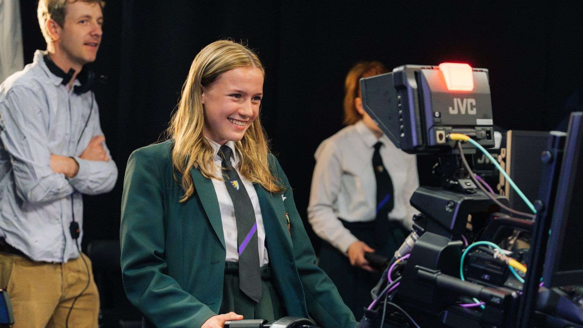 A school student tries out filming on a studio camera