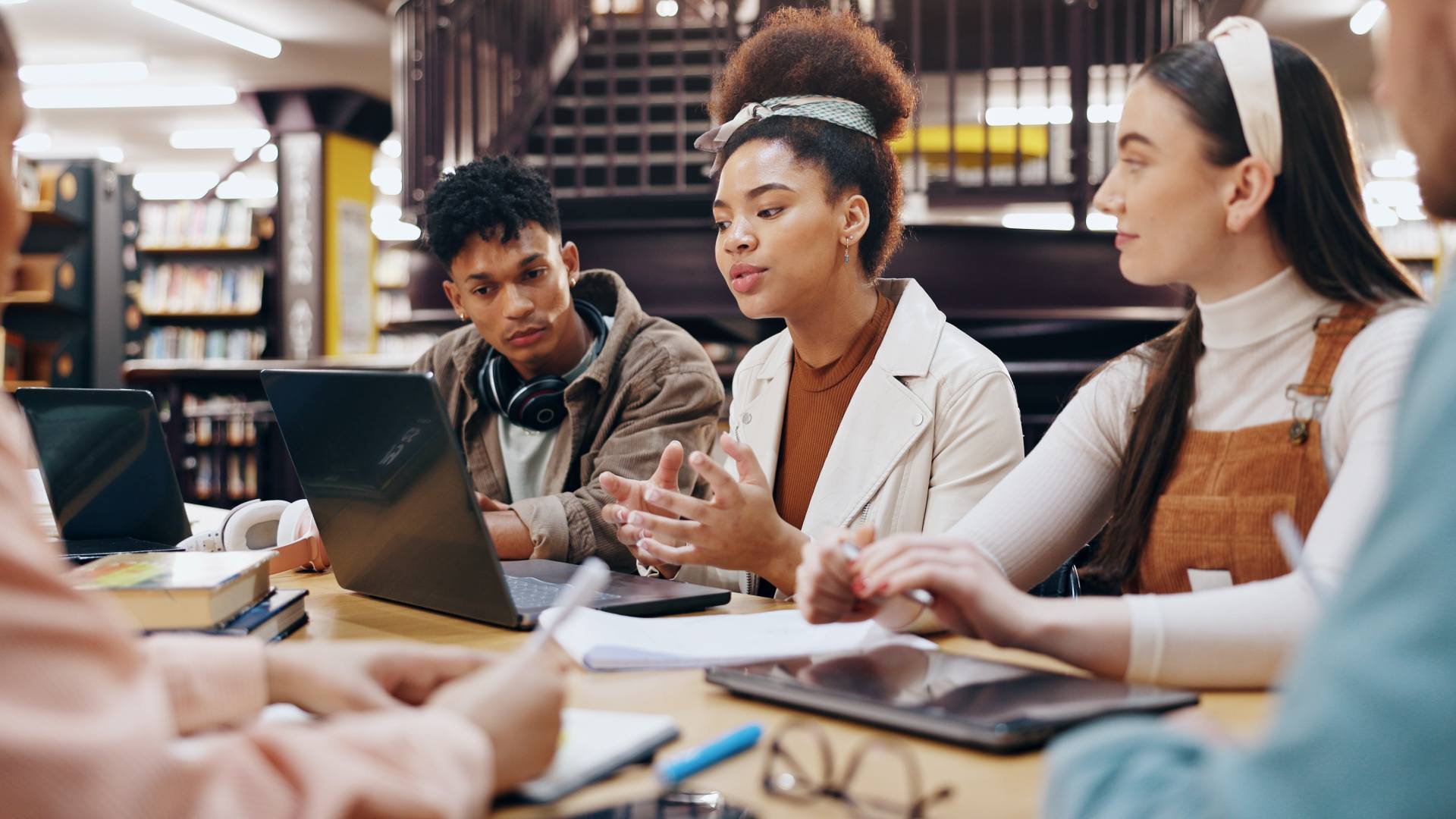 Group of people sat round a table with laptops