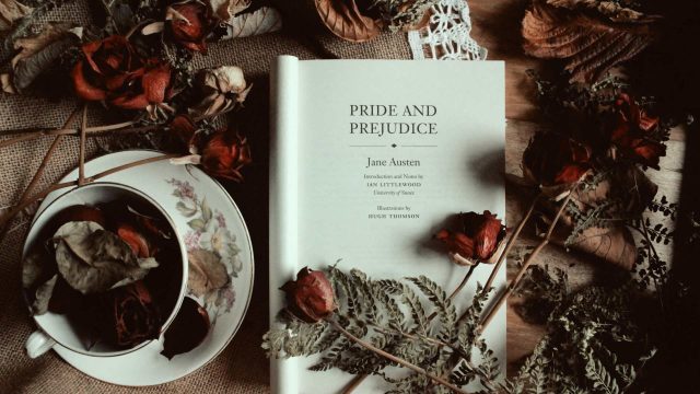 pride and prejudice books and a cup of tea beside it filled with flowers