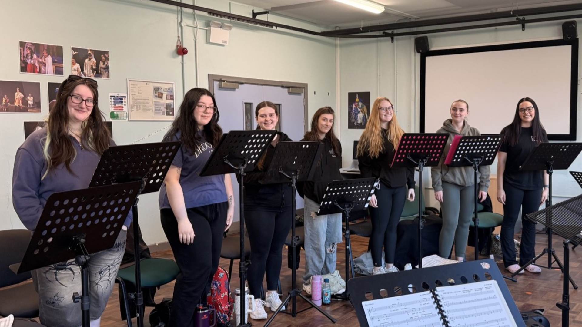 photo of the cast of this is the moment show - seven of the students standing rehearsing