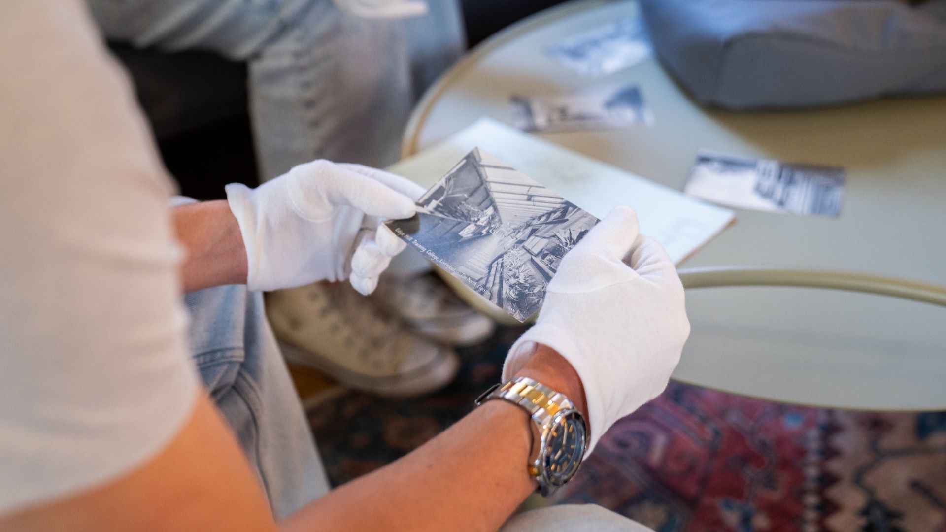Student wearing white gloves examining a historical artefact.