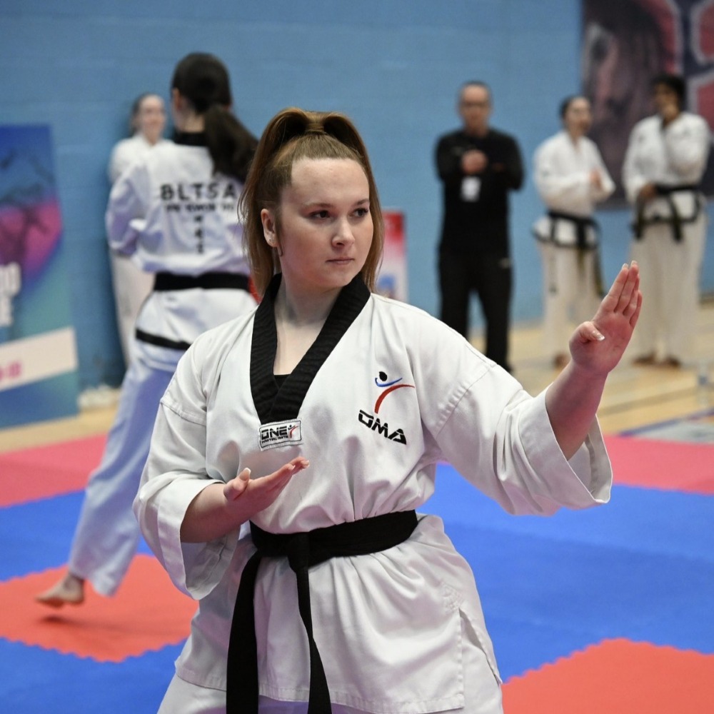 student Lilly in a Taekwondo position at a competition