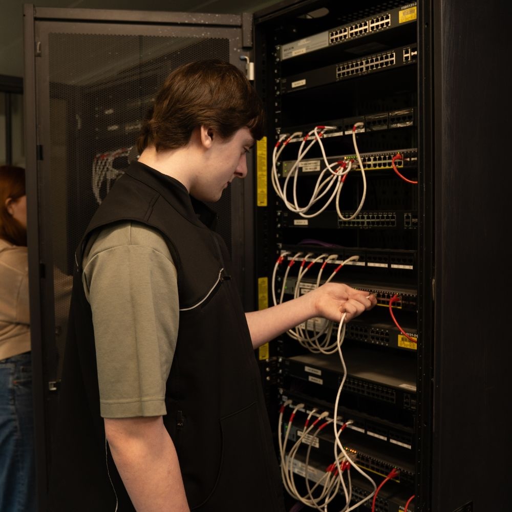 image of student looking at wires in a cuboard.
