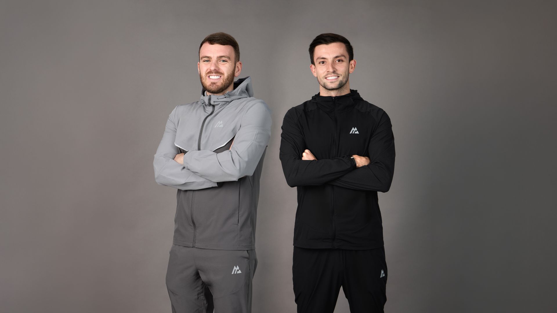 Two men wearing Montirex sportswear stand shoulder to shoulder and smile at the camera.