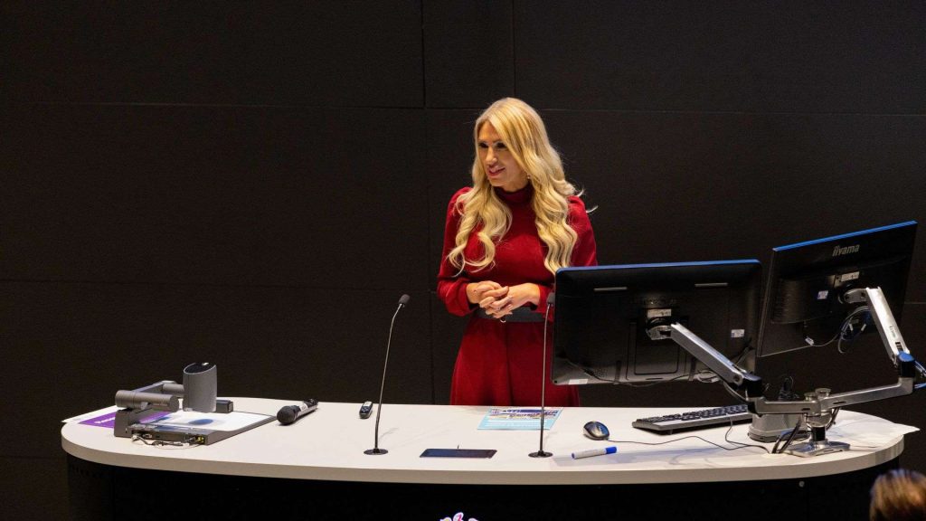 Nina Smith stands at the front of a lecture theatre talking passionately about her research into suicide prevention