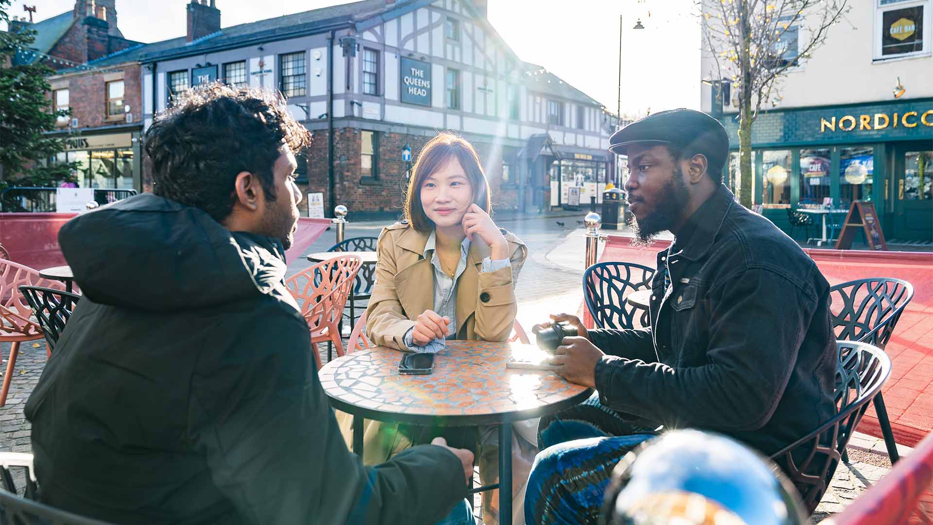 three international students sat talking in ormskirk town centre