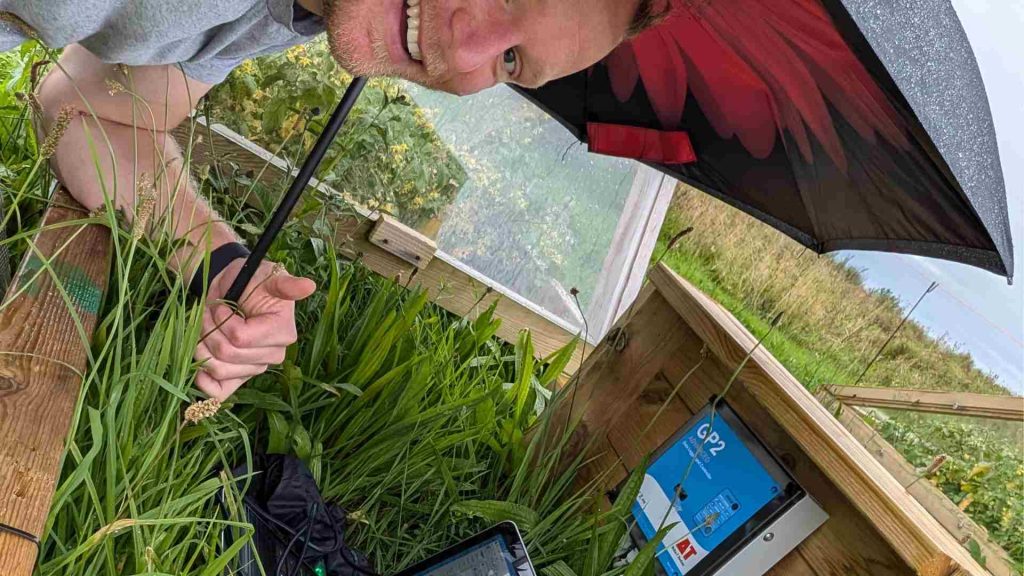 Sven Batke is in the rain in a field testing greenhouse materials.