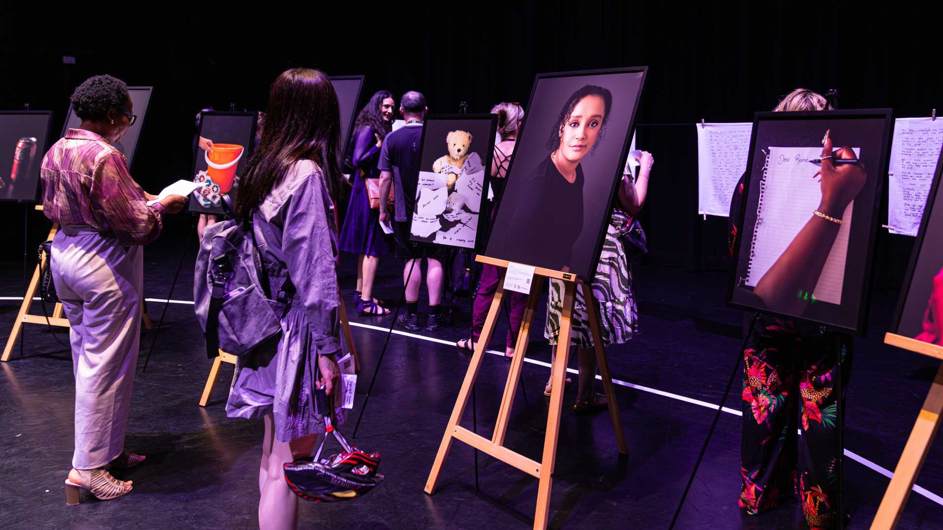 image of portraits on easles with people looking