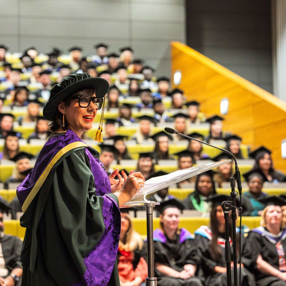 Angela with students in hall giving speech 