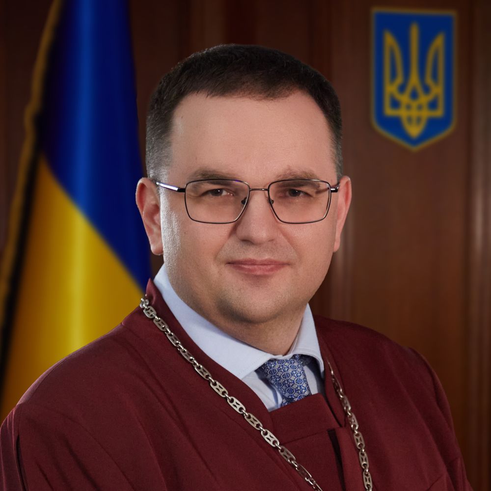 Iurii Barabash wears glasses and a ceremonial gown and gold chain.