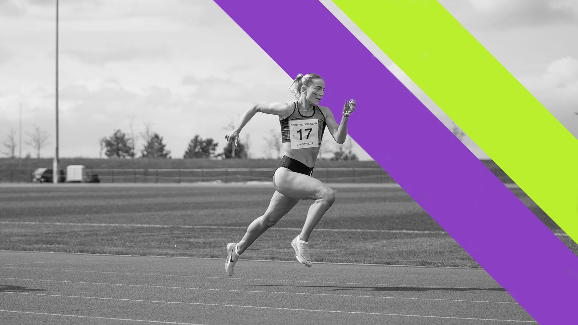 A black and white photo of an Edge Hill athlete sprinting on our athletics track, with the double sash of the Sports Centre sub-brand in the right hand side of the image