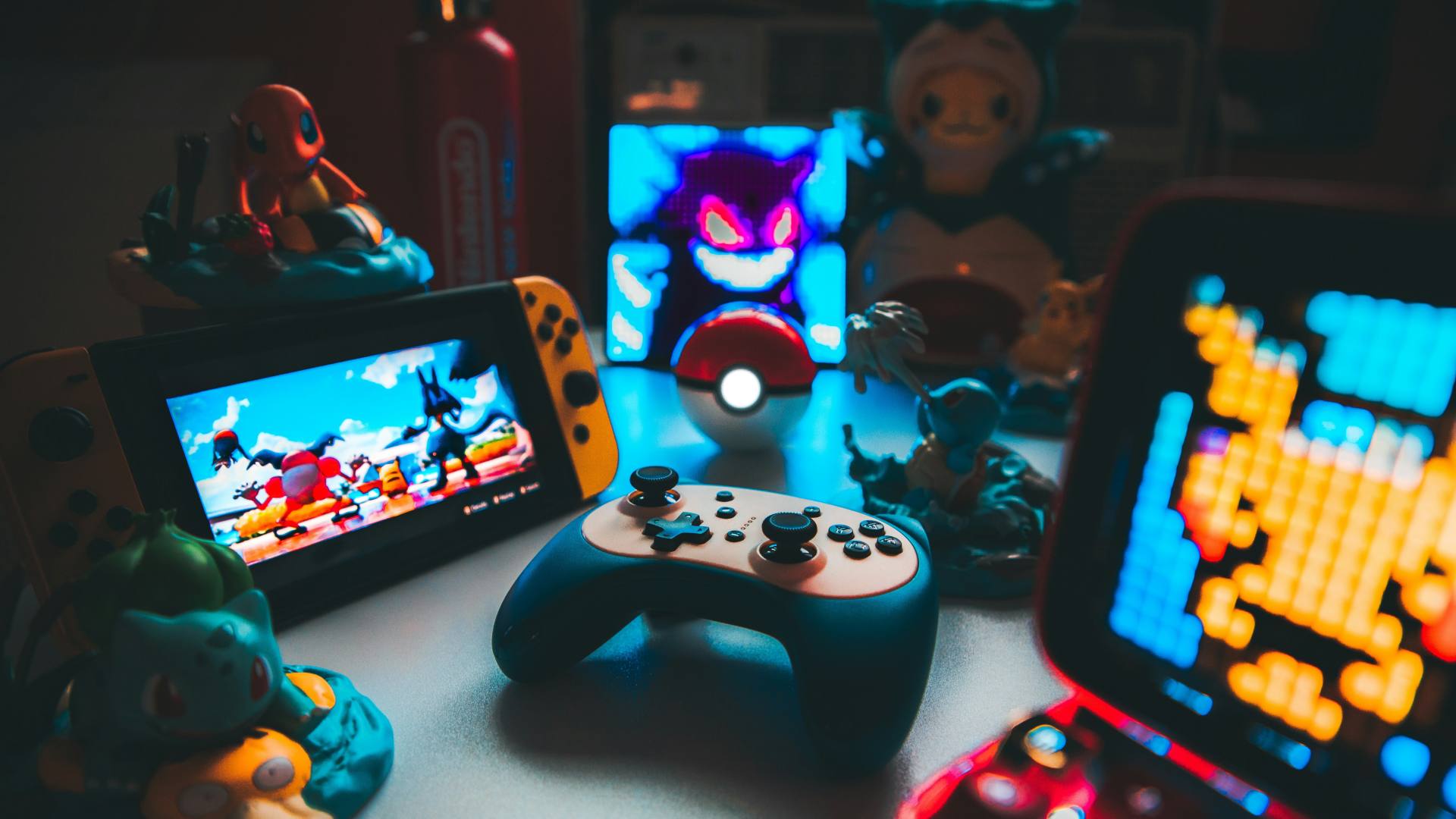 a table full of video games, handheld consoles and game figurines