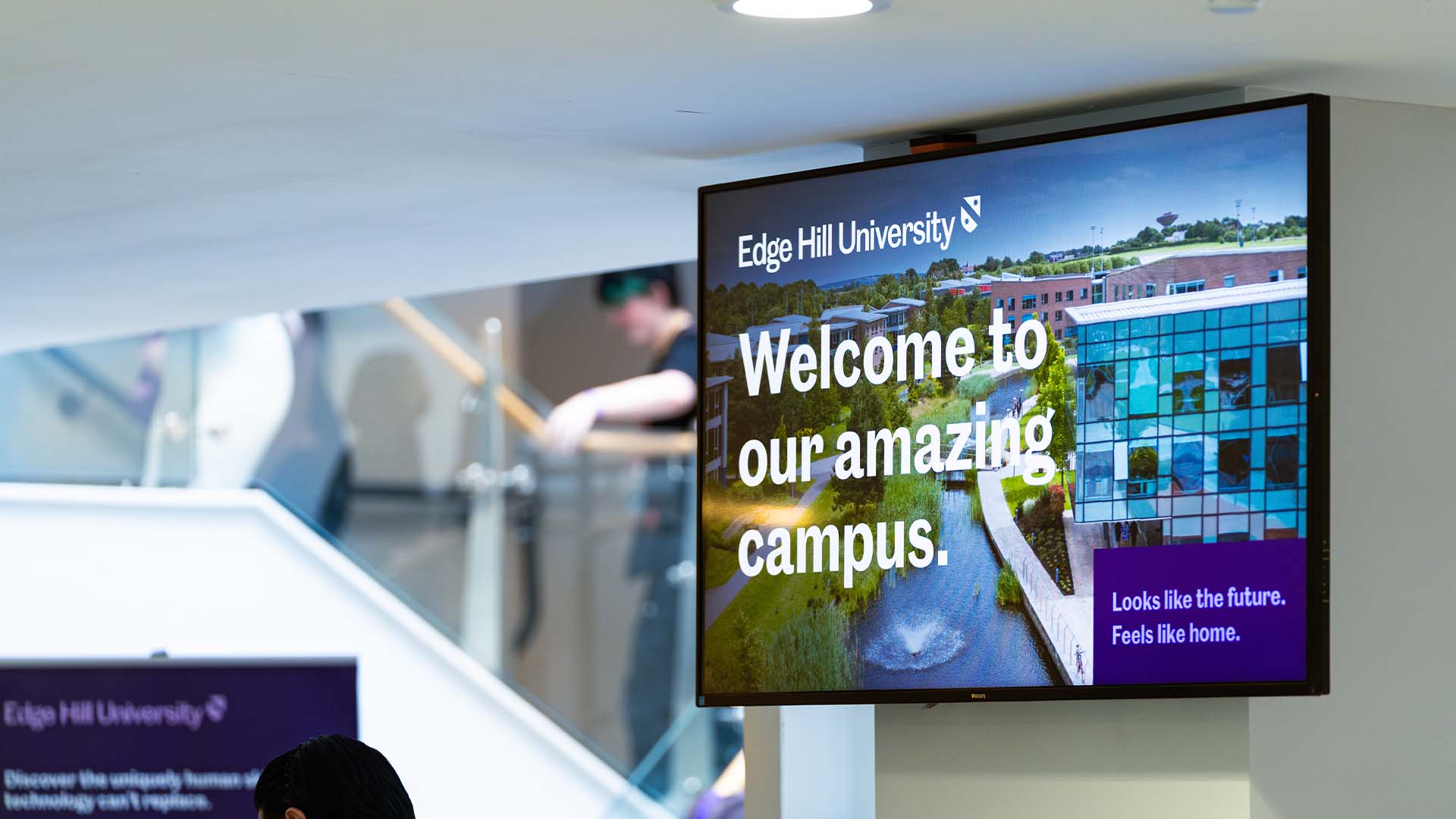 A media screen on campus with a 'Welcome to our amazing campus' message.